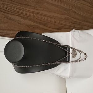 Long blackish silver tone chain with heart and beads.